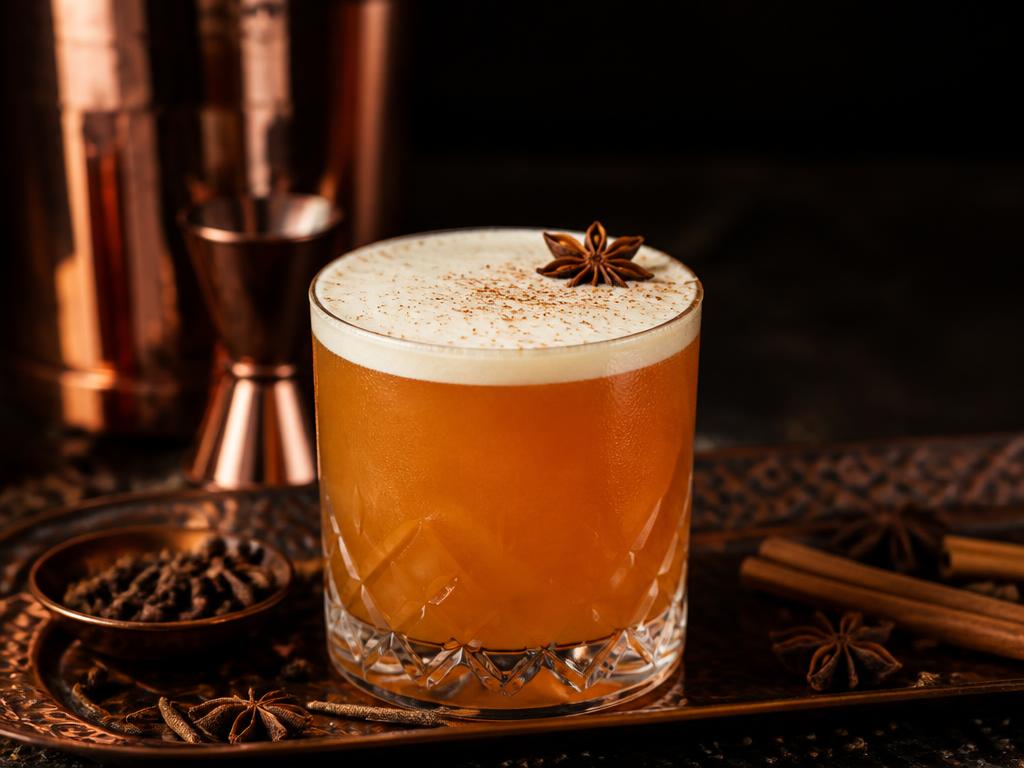 Amber spiced sour with silky foam in a rocks glass